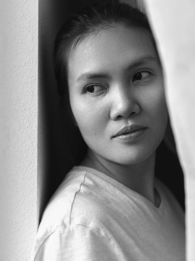 Black-and-white portrait of filmmaker Maren Halverson at her kitchen table