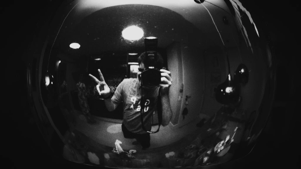 A candid black-and-white moment between a director and actor in a festival corridor.