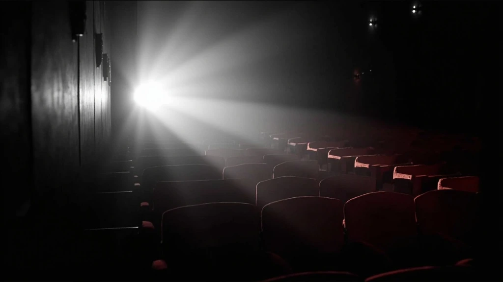 Empty cinema auditorium with projector beam, grayscale